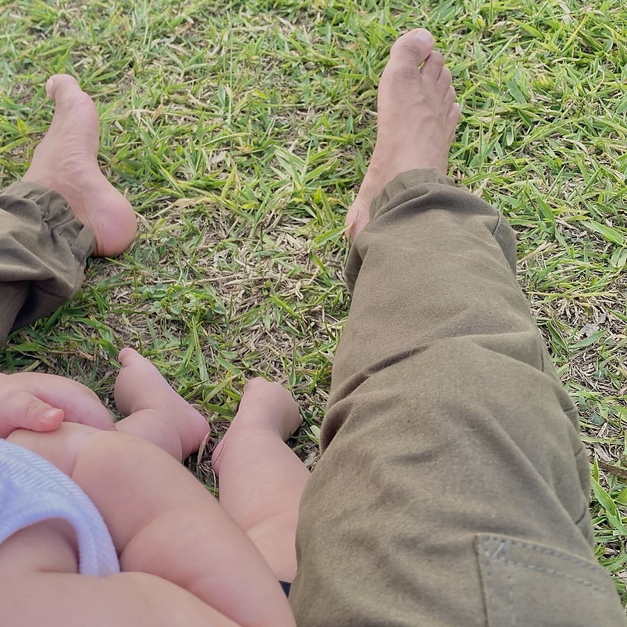 Pés de Felipe e da filha, descalços na grama